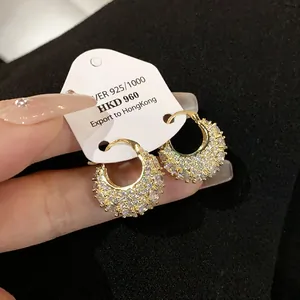 Detailed view of gold-plated zircon hoop earrings with premium display tag