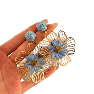 Handgemaakte lichtblauwe raffia bloem oorbellen met goudkleurige holle metalen bloemblaadjes
