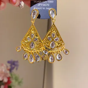 Detail of luxury gold tassel earrings with shimmering teardrop cubic zirconia stones.