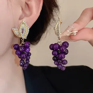 Vista dettagliata di orecchini vintage a grappolo d'uva viola con strass lucidi ed eleganti