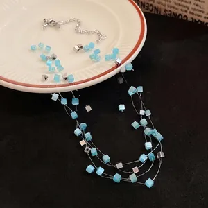 Elegant multi-strand necklace featuring blue cat's eye stone and silver square bead accents