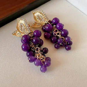 Vista dettagliata di orecchini vintage a forma di uva con perle e strass