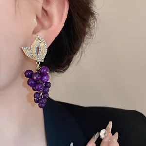Dettaglio orecchini vintage a grappolo d'uva con pietre preziose viola e microdiamanti
