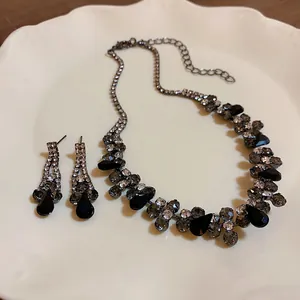 Close-up macro detail of black waterdrop rhinestone necklace and earring jewelry set