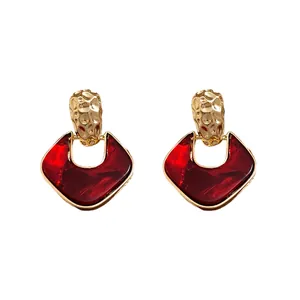 Orecchini stile retrò con pendenti in resina rossa e finitura in oro martellato elegante