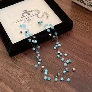 Detail of multi-layer necklace with blue square cat eye beads and silver cubes