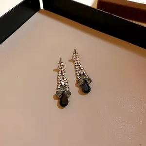 Detailed view of elegant teardrop black stone earrings with glittering rhinestones.