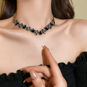 Close-up detail of an elegant fashion necklace with black water drop and clear crystals