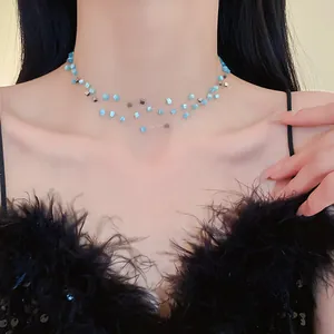 Detailed close-up showing a multi-layer choker necklace with blue square cat's-eye stones