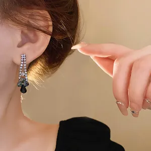 Detailed view of elegant water drop black diamond earrings worn on an ear for a luxury look