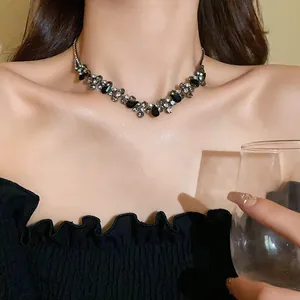 Macro detail of elegant teardrop black diamond choker necklace worn on a female model