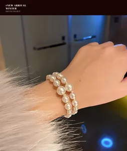 Detailed view of elegant double-strand pearl bracelet with sparkling spacers on wrist