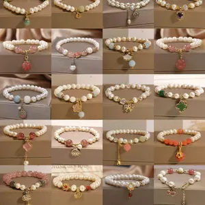 Multiple elegant French style pearl bracelets with various charm designs displayed
