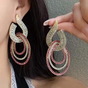 Nahaufnahme von elegant funkelnden Strass-Hohlohrringen mit rosa und weißen Steinen