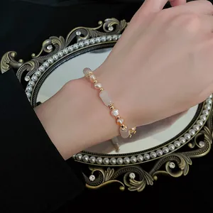 Detail of French minimalist bracelet with pink pearls and translucent stones on wrist
