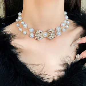 Vista dettagliata dell'elegante collana di perle a due fili con un fiocco di strass lucente
