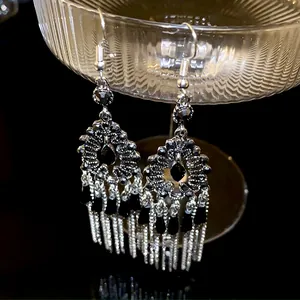 Eleganti orecchini pendenti vintage in argento con strass neri su supporto di vetro.