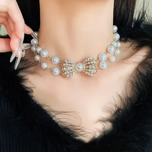 Elegante collana a doppio filo di perle sintetiche con fiocco di strass luccicanti