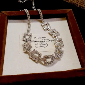 Close-up of silver double-layer necklace with rhinestone square geometric links in a box