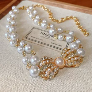 Primo piano dettagliato di una collana di perle finte a doppio strato con fiocco di strass