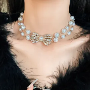 Dettaglio di un'elegante collana di perle a due fili con fiocco di strass lucido