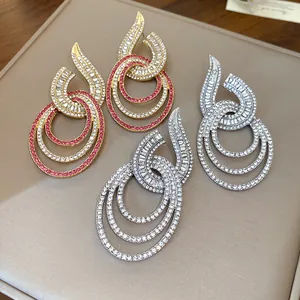 Nahaufnahme von funkelnden, mit Strass besetzten, mehrlagigen runden Ohrringen in Gold und Silber