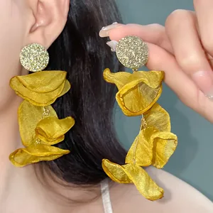 Close-up of elegant yellow chiffon flower tassel earrings with crinkled petal detail