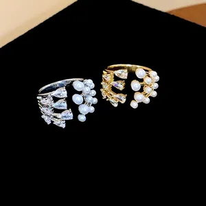 Close-up detail of multi-layer open rings featuring white pearls and marquise zircons