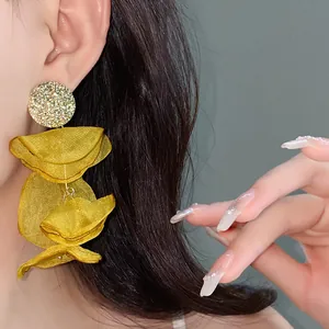 Close-up of yellow chiffon flower tassel earrings for a romantic seaside holiday look