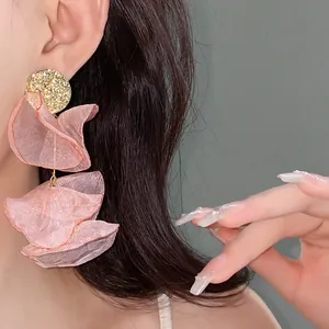 Detailed view of pink pleated chiffon flower tassel earrings with golden studs.