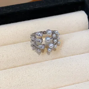 Detailed view of an elegant multi-layer open ring set with zirconia and lustrous pearls