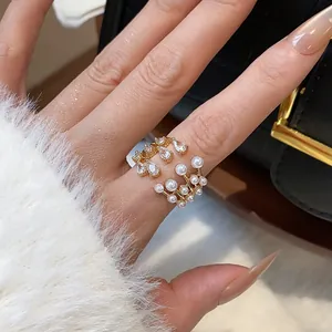 Detailed close-up of a luxury multilayer open ring featuring white pearls and zircons on finger