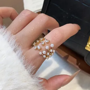 Macro view of multi-layer gold open ring featuring elegant pearls and sparkling zircons