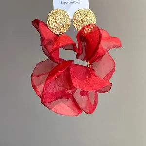 Detail of ruffled red chiffon petals and hammered gold stud of the flower earring