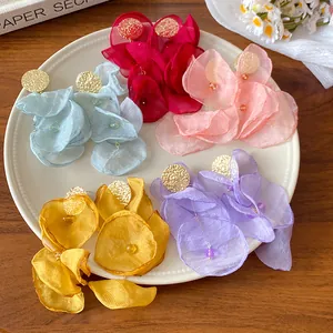 Close-up of pleated chiffon flower tassel earrings in multiple colors on a white plate