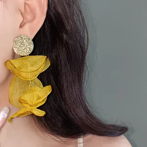 Close-up shot showing detailed yellow chiffon flower tassel earrings on model's ear