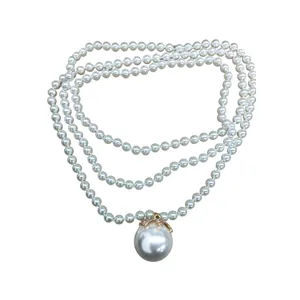 Elegant multi-layer pearl necklace featuring a large diamond-studded pearl pendant.