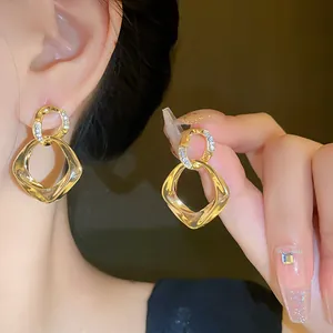 Detailed view of elegant gold twisted geometric dangle earrings with stone accents