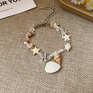 Macro view of vacation style bracelet with natural stones, stars, and shell charms.