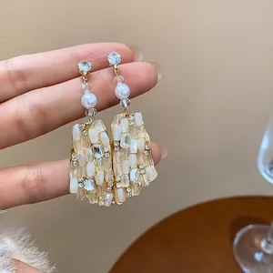 Nahaufnahme von unregelmäßigen Vintage-Ohrringen mit Strasssteinen und Perlen