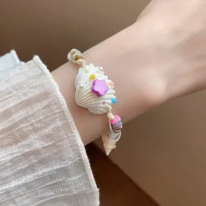 Close-up of handmade beaded bracelet featuring a natural conch, pearls and star charm.