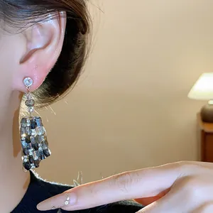 Nahaufnahme von luxuriösen, unregelmäßigen quadratischen Glasohrringen mit Strasssteinen