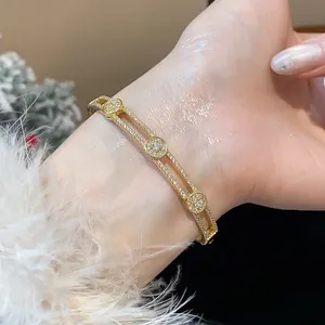 Vue détaillée d'un élégant jonc à fleurs plaqué or 18 carats orné de zircons brillants
