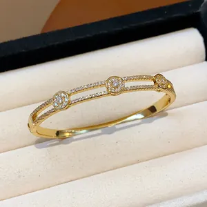 Gros plan détaillé d'un jonc à fleurs en zircon plaqué or 18 carats dans un écrin