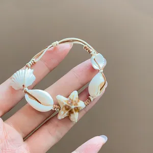 Close-up of a vacation style braided bracelet with shells and a ceramic starfish