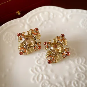 Vintage gold-tone stud earrings with oval champagne gemstone and amber crystals.