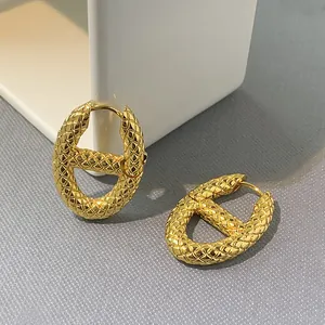 Detailed view of gold-tone H-link earrings featuring a unique quilted texture pattern