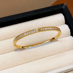 Détail d'un élégant bracelet jonc plaqué or 18 carats orné de zircons scintillants