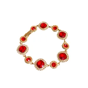 Elegante bracciale placcato oro con gemme rosse vibranti e accenti di zirconi trasparenti