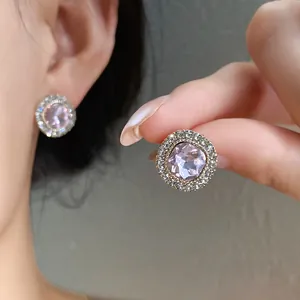Primo piano di eleganti orecchini a lobo con cristallo rosa e strass luccicanti